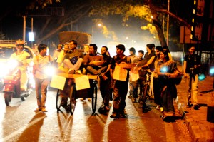 On the way Around 16 people, walking and pushing bikes and a cart.