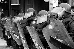 A line of riot police with helmets and shields